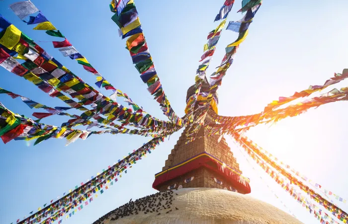 Langtang Valley – Prayer flags flying against the sun from the Boudhanath Stupa Day 1